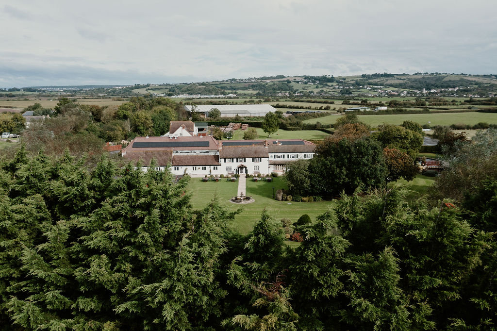 Batch Country House seen across the treetops, with the Somerset countryside behind